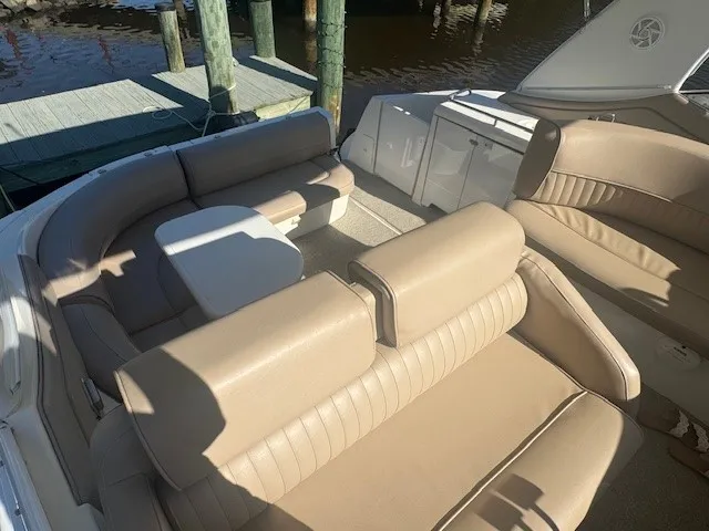 Overhead view of the boat’s seating area with beige cushions and a white table, dock visible in the background.