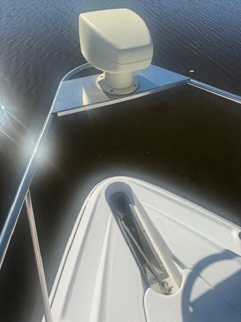 Bow of the boat showing anchor slot and a mounted device on a small platform over the water.