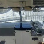 Dry cabin interior of Trophy 2359 Walkaround with cushioned seating, helm controls, and forward berth.